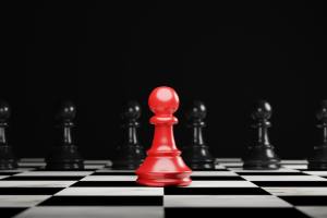 Red pawn chess stepped out of line to leading black chess and show different thinking ideas. Business technology change and disruption for new normal concept.
